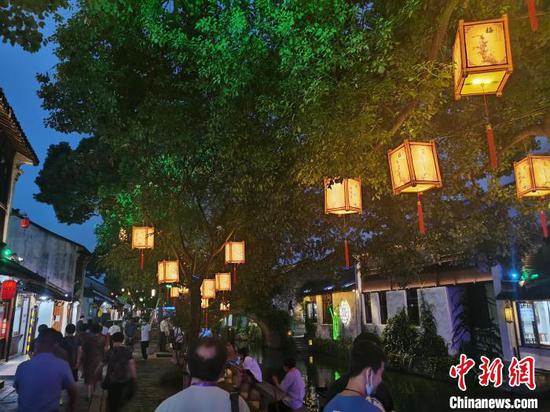 Κόσμος επισκέπτεται μια παραδοσιακή πόλη διακοσμημένη με φανάρια στο Κουνσάν, στην επαρχία Τζιανγκσού της ανατολικής Κίνας, 8 Σεπτεμβρίου 2022. (Photo/China News Service)