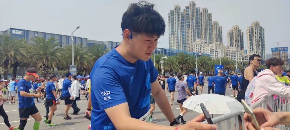 He Shuai arată contul online de maraton al tatălui. (Foto: Xinhua)