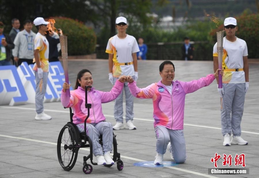 Η Ταν Γιουτζιάο (αριστερά) δίνει τη φλόγα στον Λέι Μινγκ κατά τη διάρκεια της λαμπαδηδρομίας των 4ων Ασιατικών Αγώνων Para Games στην κομητεία Τσουν’αν, Χανγκτζόου, στην επαρχία Τζετζιάνγκ της ανατολικής Κίνας, 19 Οκτωβρίου 2023 (Φωτογραφία: China News Service/Wang Gang)