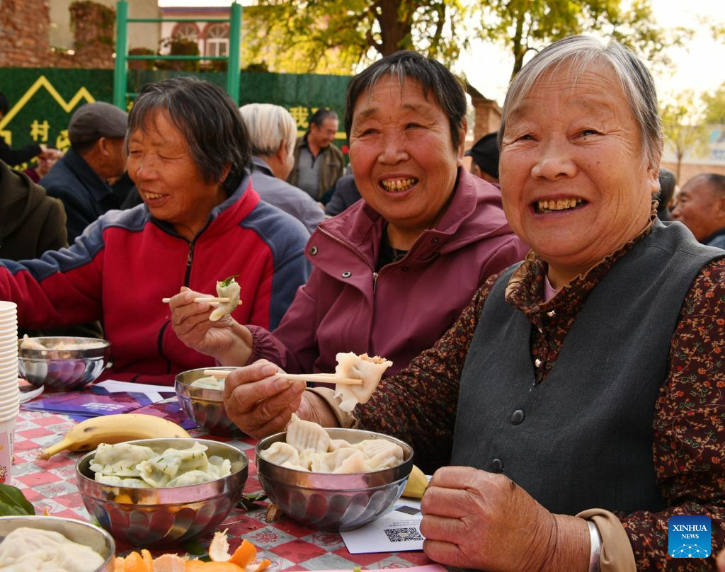 Ηλικιωμένοι τρώνε κουλουράκια σε μια πλατεία στο χωριό Ντονγκλιτζουάνγκ της περιοχής Λουατσένγκ στο Σιτζιατζουάνγκ, στην επαρχία Χεμπέι της βόρειας Κίνας, στις 22 Οκτωβρίου 2023. (Φωτογραφία Li Mingfa/Xinhua)