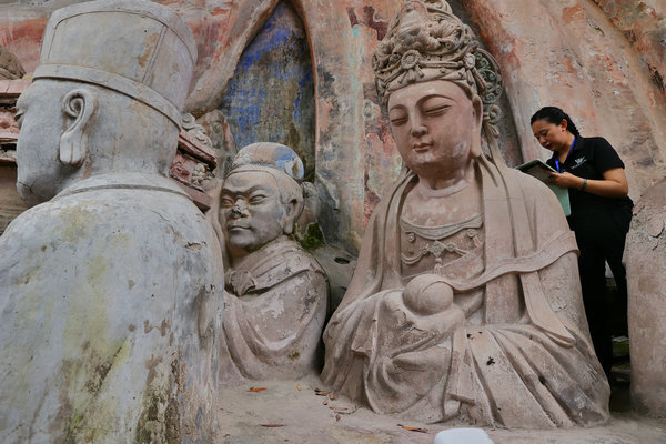 Ένα μέλος της Ακαδημίας Πολιτιστικής Κληρονομιάς της Κίνας διεξάγει έρευνα για τα αγαλματίδια στο Νταζού. [Τζιανγκ Ντονγκ/China Daily]