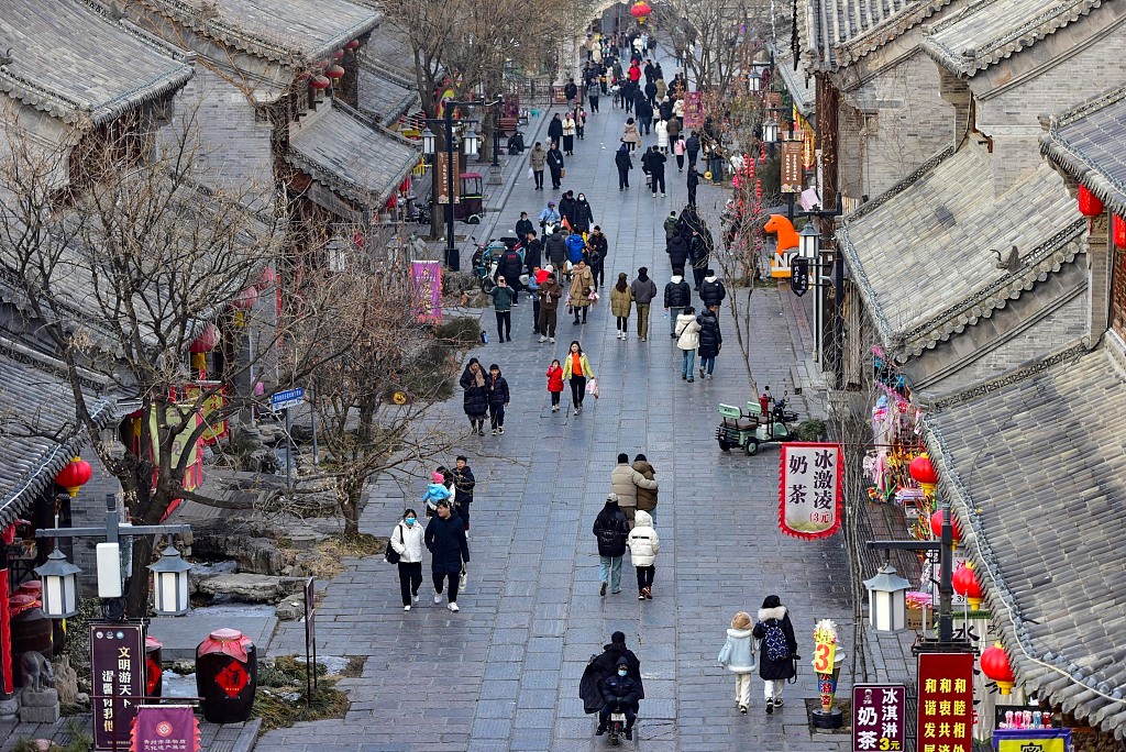 Επισκέπτες περπατούν σε έναν τουριστικό δρόμο στο Γουεϊφάνγκ, στην επαρχία Σανντόνγκ της Ανατολικής Κίνας, την 1η Ιανουαρίου 2024. [Φωτογραφία/VCG]