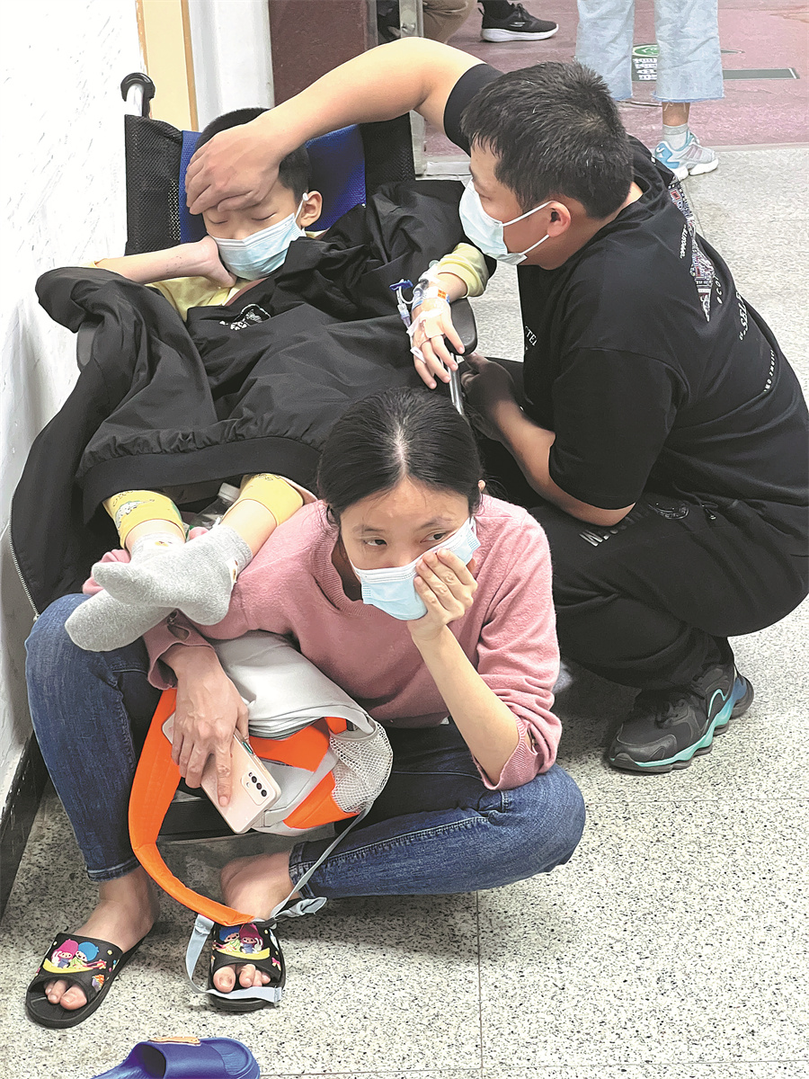 Με τη γρίπη να χτυπά ορισμένα μέρη της Κίνας κατά τη διάρκεια του χειμώνα, γονείς φροντίζουν το γιο τους σε ένα νοσοκομείο στο Γκουανγκτζόου, επαρχία Γκουανγκντόνγκ, στις 12 Δεκεμβρίου. WU MING/NANFANG DAILY