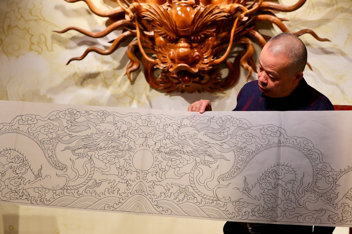 Ο Τζενγκ Μπαοσού, εκπρόσωπος της τέχνης της ξυλογλυπτικής του ναού του Πανσάν,  παρουσιάζει ένα σχέδιο δράκου στο χωριό Πανσάν, Τζιντζιάνγκ, επαρχία Φουτζιέν, 27 Ιανουαρίου 2024. [Φωτογραφία από Jiang Kehong/ Για chinadaily.com.cn]