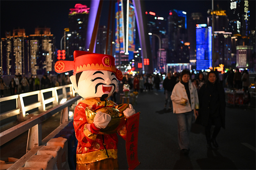 Ο Θεός του Πλούτου προσελκύει τουρίστες στη γέφυρα Τσιενσιμέν στο Τσονγκτσίνγκ της νοτιοδυτικής Κίνας, 16 Φεβρουαρίου 2024. [Φωτογραφία/VCG]