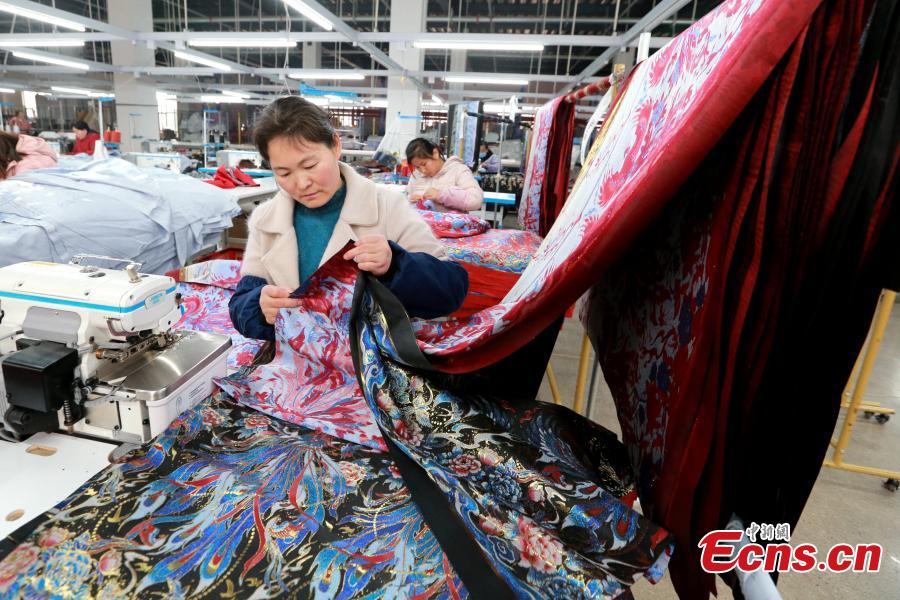 Μοδίστρες ράβουν το κομμένο ύφασμα σε ένα εργοστάσιο ρούχων στην κομητεία Τσαοσιέν,  στην επαρχία Σανντόνγκ της ανατολικής Κίνας, 4 Μαρτίου 2024. (Φωτογραφία: China News Service/Liang Ben)