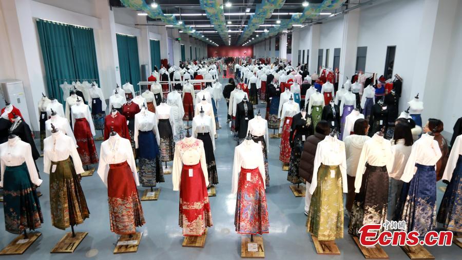 Πελάτες επιλέγουν φούστες μαμιεντσούν σε ένα εργοστάσιο ένδυσης στην κομητεία Τσαοσιέν,  στην επαρχία Σανντόνγκ της ανατολικής Κίνας, 4 Μαρτίου 2024. (Φωτογραφία: China News Service/Liang Ben)